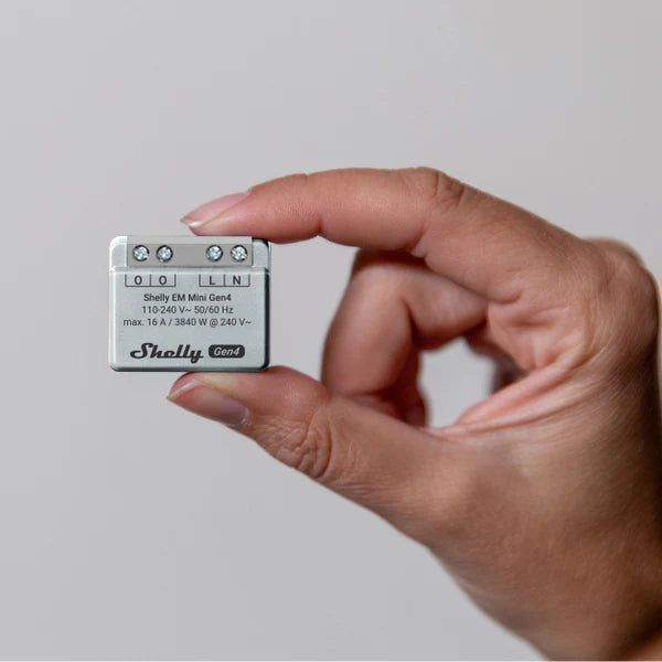 Hand holding a Shelly EM Mini Gen4 against a neutral background | Lykalyte