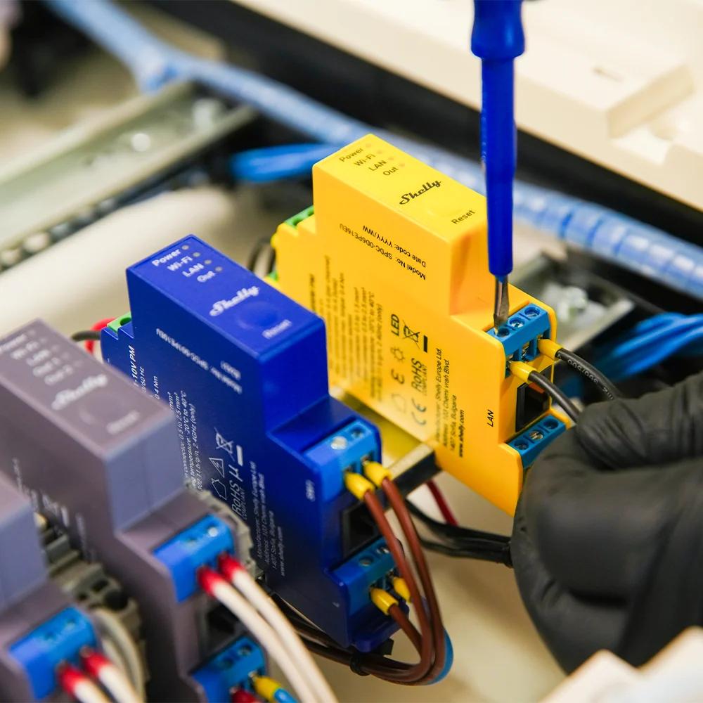 Shelly Pro RGBWW PM yellow DIN mount relay on a din rail with other Shelly relays being wired | Lykalyte